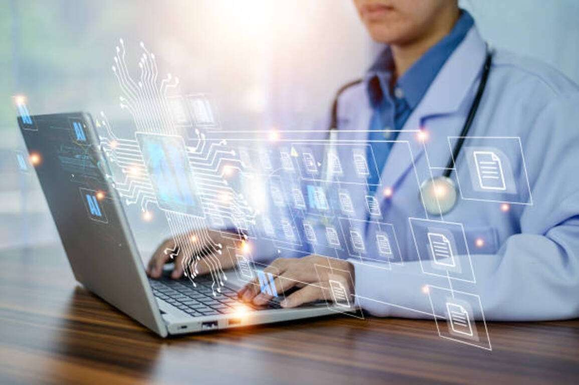 Doctor using a laptop with digital health data overlays